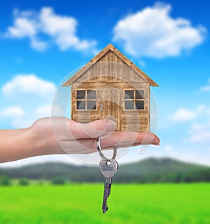 Wooden house with key in hand