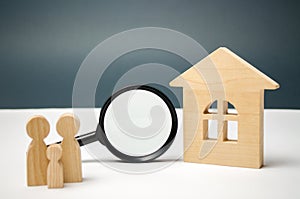 Wooden house and magnifying glass with family. Property valuation. Choice of location for the construction. House searching