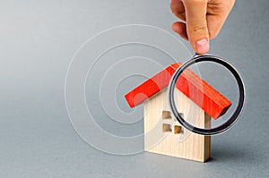 Wooden house and magnifying glass. Property valuation. Home appraisal. Choice of location for the construction. House searching