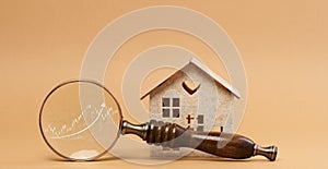 Wooden house and a magnifying glass, representing the concept of real estate purchase