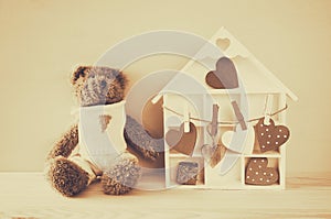 Wooden house with many hearts and cute teddy bear