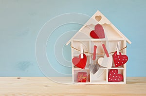 Wooden house with many hearts on the table