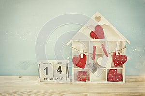 Wooden house with many hearts on the table