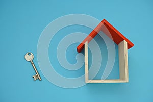 Wooden house model on blue background.