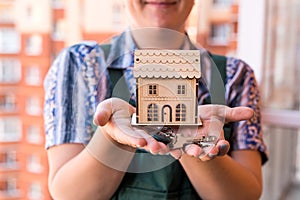 Wooden house model with female hands and keys