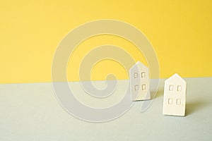 Wooden house model on gray and yellow background. Real estate concept