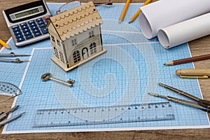 Wooden house model with key on millimeter paper