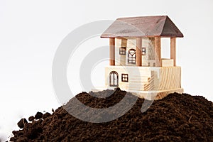 Wooden house model on the pile of soil