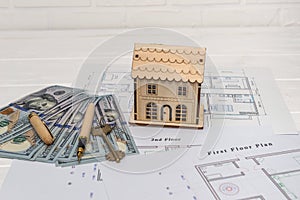 Wooden house model with real key on blueprint