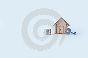 Wooden house model, stocks money and key on blue background. Concept of buying and selling homes and real estate. Home Insurance,