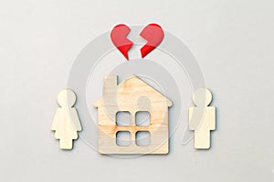 Wooden house and models of man and woman with red broken heart, divorce, end of relationship and  marriage concept