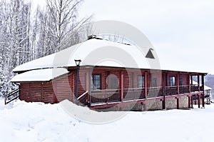 Wooden house in mountain in winter time. Log cabin in forest alone in wilderness. Wooden house with a wooden roof against