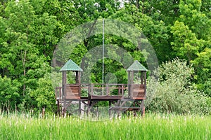 Wooden house in nature for hunters and bird photographers. Hunting watchtower. Wooden lookout tower for birdwatchin