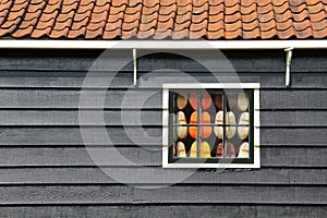 The wooden house of Netherlands and a window full of clogs inside.