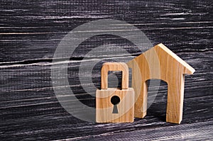 Wooden house with a padlock. House with a lock. Security and safety, collateral, loan for a mortgage. Confiscation of property