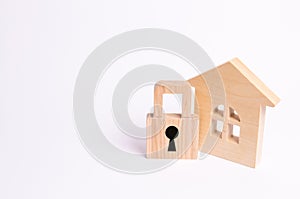 Wooden house with a padlock. House with a lock. Security and safety, collateral, loan for a mortgage. Confiscation of property
