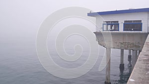 Wooden house on piles in water, Ocean Beach pier, foggy California coast, USA.