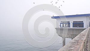 Wooden house on piles in water, Ocean Beach pier, foggy California coast, USA.