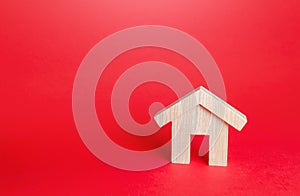 Wooden house on a red background. Buying and selling. Housing, realtor services. Mortgage loan. Construction industry, building