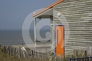 Wooden house at the shore with an orange door