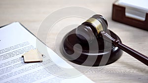 Wooden house sign on document, gavel lying on sound block, property law