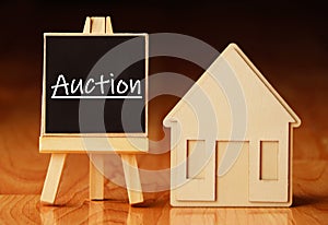 Wooden house stand with a sign auction. Selling a house or apartment and property. housing and real estate.