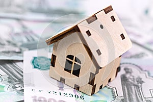 Wooden house symbol with money