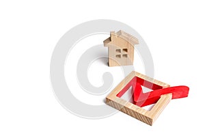 Wooden house and a tick in the box. concept of finding a home and moving to a new home. Standardization
