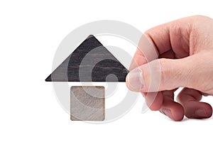 Wooden house toy blocks isolated white background, little wooden home with hand. The concept of buying and selling real estate,