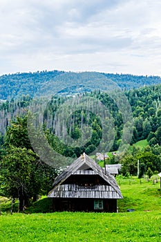 Wooden house of Ukrainian villagers in the scenery Carpathians