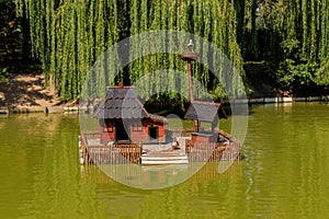 Wooden house for water birds and turtles on lake in city park