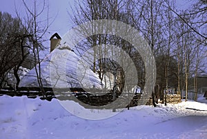 Wooden house in a winter forest under a snow cap