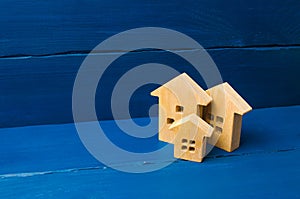 Wooden houses on a blue background. The concept of housing and real estate. Buying and buying a home, selling and investing.