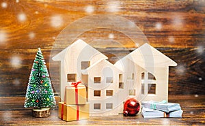 Wooden houses, Christmas tree, money and gifts. Christmas Sale of Real Estate. New Year discounts for buying housing. Purchase