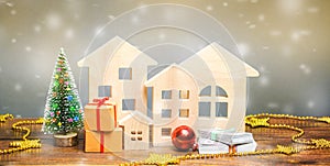 Wooden houses, Christmas tree, money and gifts. Christmas Sale of Real Estate. New Year discounts for buying housing. Purchase