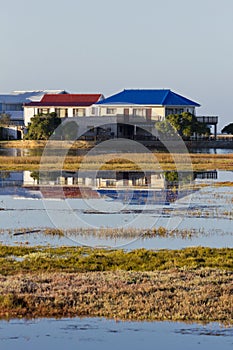 Wooden houses next to a lake or lagoon