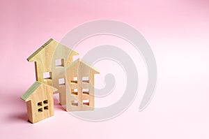 Wooden houses on a pink background. The concept of the city or town. Investing in real estate, buying a house. Management