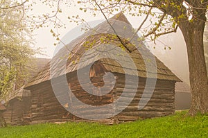 Wooden houses in Podsip mountain village during misty morning in Sipska Mala Fatra mountains