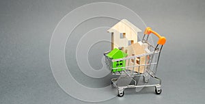 Wooden houses in a Supermarket trolley. The concept of buying a house or apartment. Affordable housing. Profitable and cheap loans photo