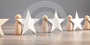 Wooden human figures with stars. Best customer evaluation and satisfaction photo