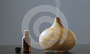 wooden humidifier for essential oils, with steam smoke, gray background