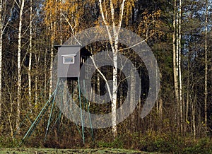 Wooden hunter box in sunny autumn forest