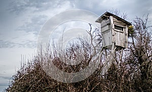 Wooden hunting watchtower under cloudy autumn sky photo