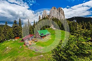 Wooden hut in the forest glade and cliffs in background photo