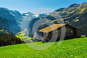 Wooden hut on the green field with Lauterbrunnen valley view