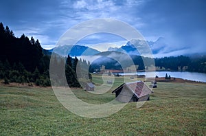 Wooden hut and morning fog over Geroldsee lake