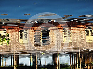 Wooden hut on stilts reflected in the waters of Inle Lake