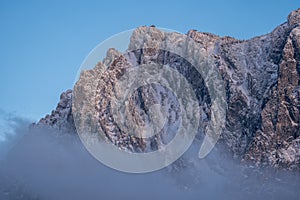 A wooden hut at the top of the mountain in winter with fog