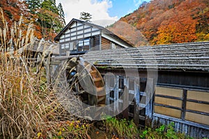 Wooden hut with water wheel among the forrest in autumn, Tsuru-no-yu Onsen - Senboku, Akita, Japan