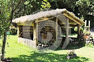 Wooden hut with wooden chairs under the straw roof in the countryside Madeira, Portugal